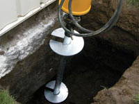 Installing a helical pier system in the earth around a foundation in Metairie