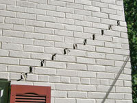 Stair-step cracks showing in a home foundation in Amite